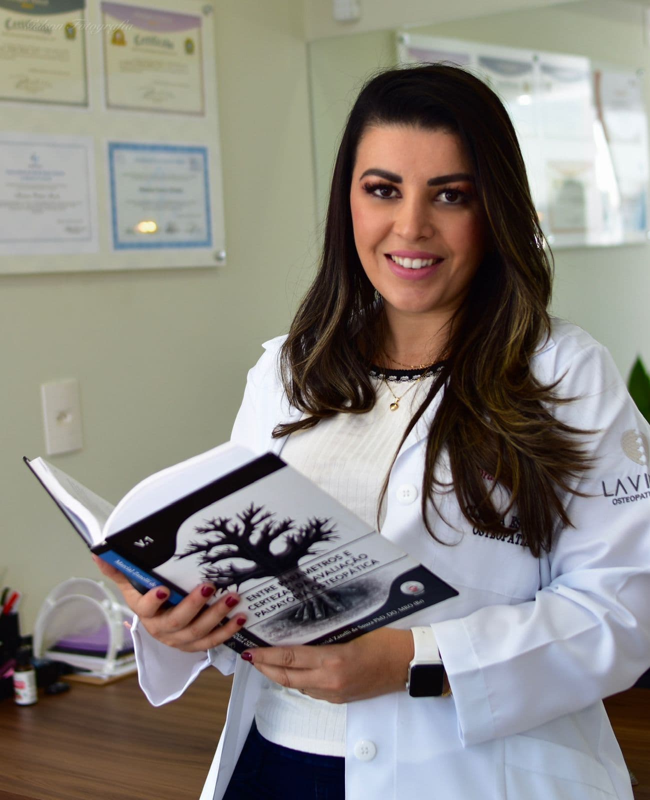 Mariana Mendes da Lavitali Osteopatia e Pilates segurando livro de osteopatia